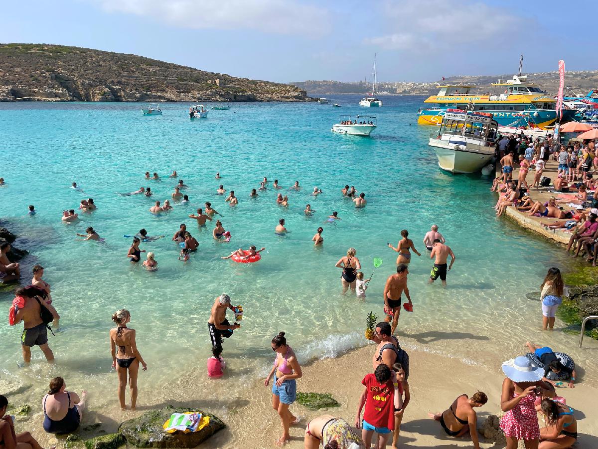 a lot of people are having fun in a small beach in Blue Lagoon