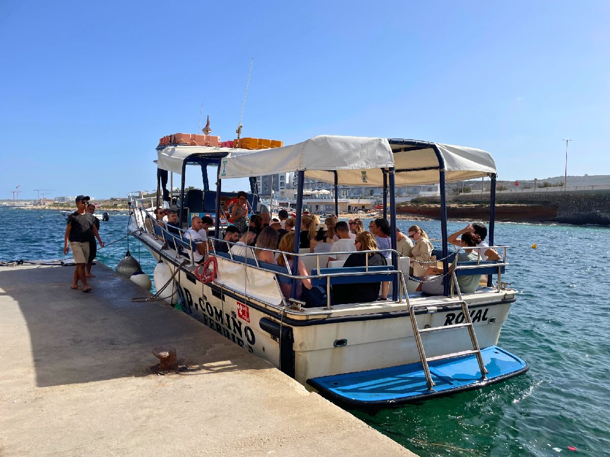 tourists taking white small Ferry to Comino Island