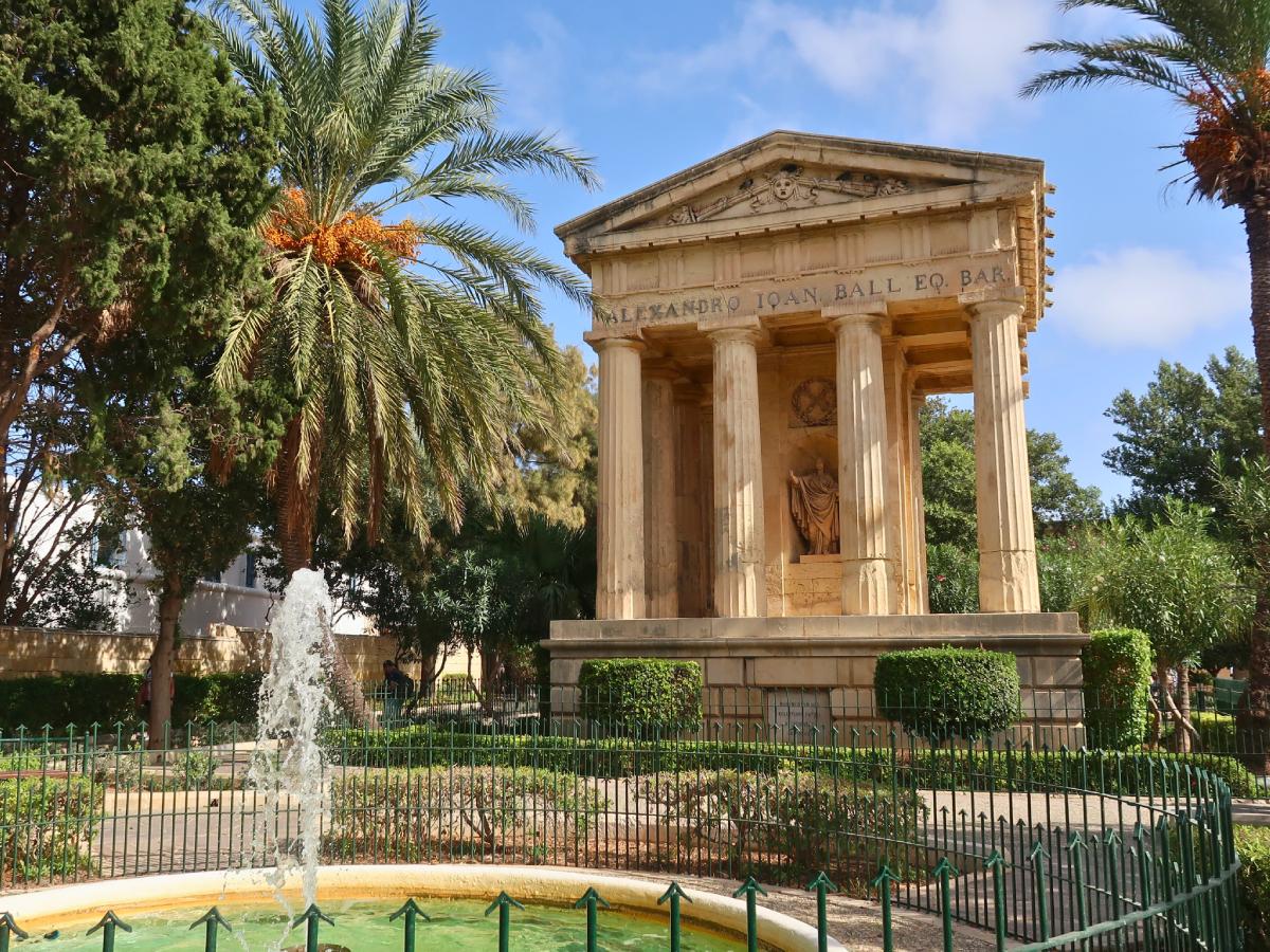 Fountain with palm trees and historical monument in Lower Barrakka Gardens