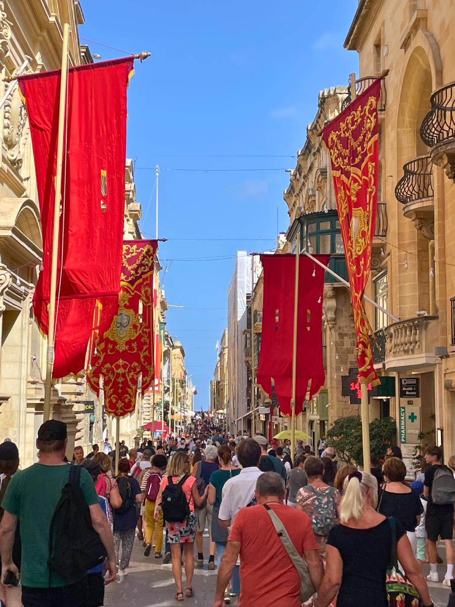 Republic Street in Valletta with a lot of tourists and red flags hanging all around