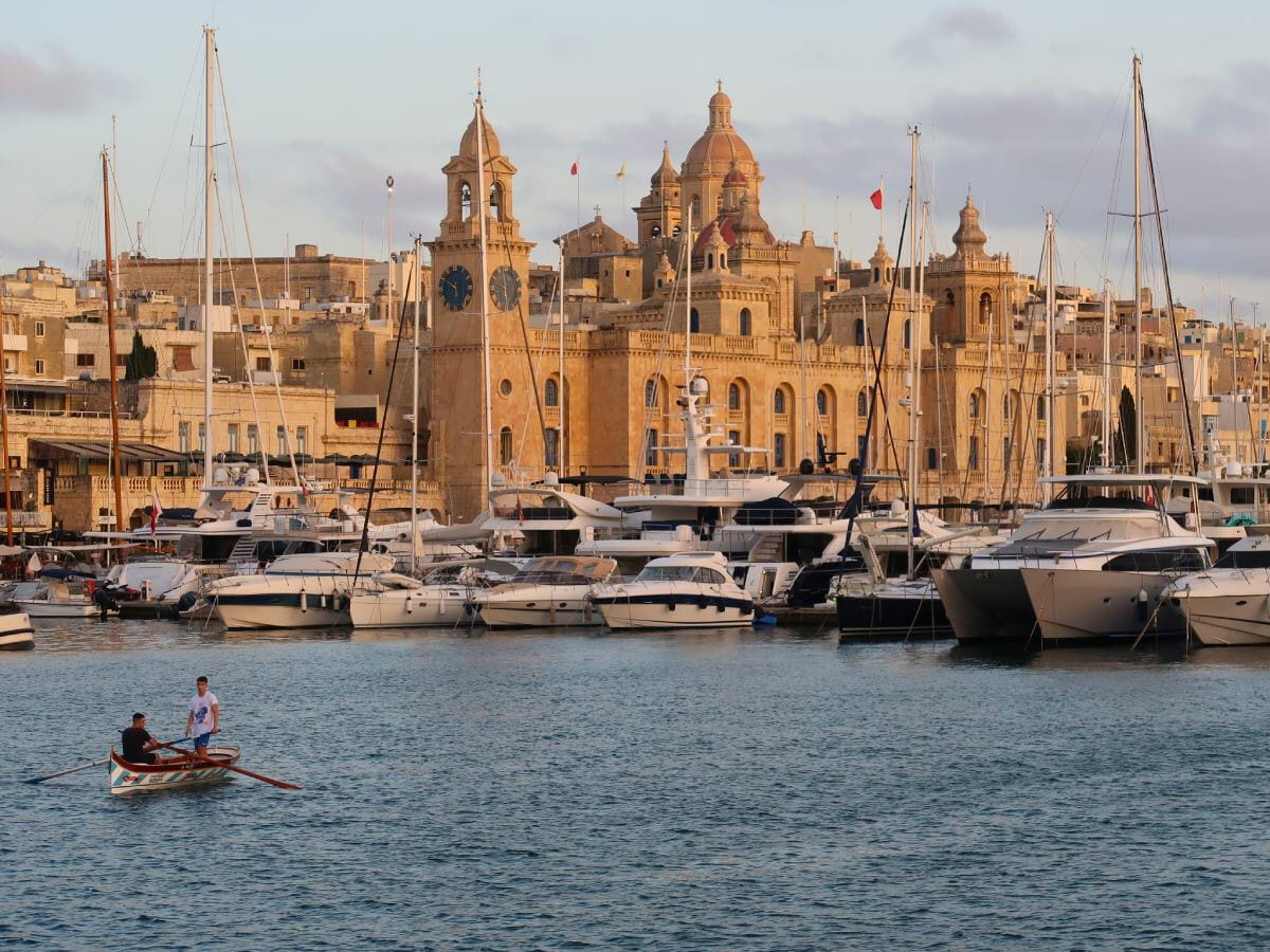 Three Cities with yachts and two people on very small boat